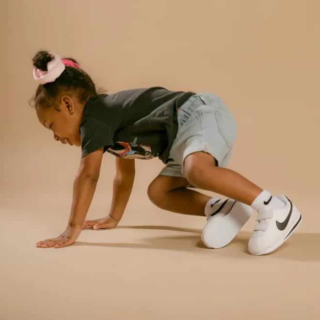 little girl wearing white Nike sneakers